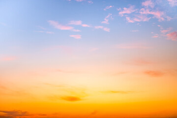 Obraz premium Sunset or sunrise sky with a vibrant gradient of orange, gold, and soft blue. Clear atmosphere with wispy clouds. Peaceful, natural light background. hope, freedom, new day and inspirational Concepts