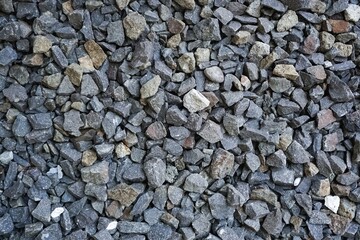 Full frame background of rough grey and brown crushed stone or gravel texture.