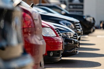Various parked luxury cars lined up in a modern parking area during daytime