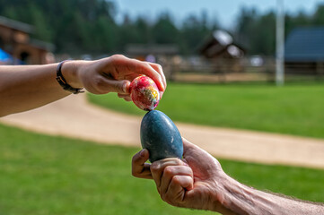 Colorful Easter egg cracking competition in a sunny park during spring festivities