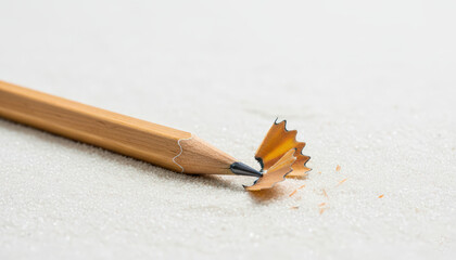 Wooden pencil with sharpener shavings on white background  