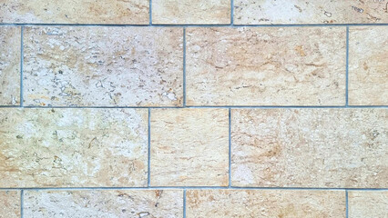 Light Beige Travertine Wall Texture: Natural stone facade with rough, porous surface and grout lines. Elegant, rustic exterior or interior architectural background.