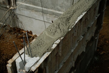 Reinforcement Steel Rebar Cage and Concrete Wall Foundation during Construction. Structural Engineering Detail.
