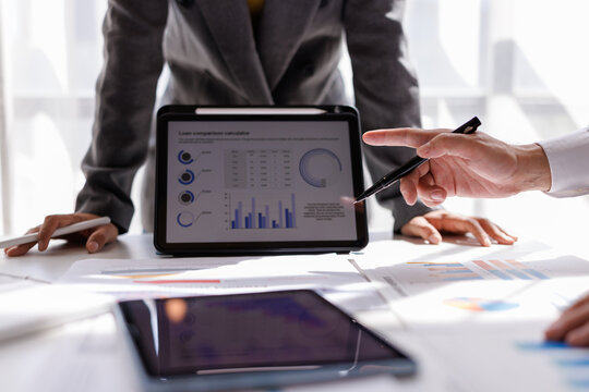 Financial Analysis. Business team woman calculating data with calculator and laptop in modern office.
