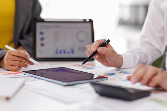 Financial Analysis. Business team woman calculating data with calculator and laptop in modern office.
