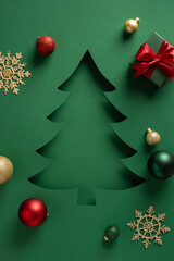 A green card features a festive Christmas tree cutout surrounded by ornaments and a gift box,...