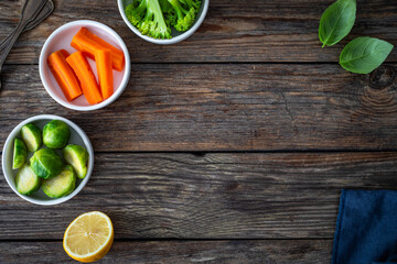 Empty woden table with vegetables, lemon and napkin on side. Top view