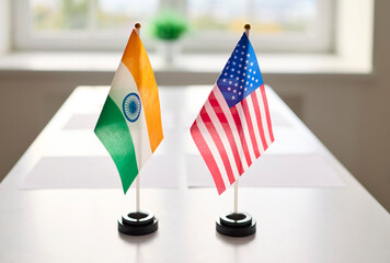 Flags signal diplomacy, meeting and negotiation at table. India and USA flags signal bilateral...