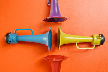 Plastic horn on a red background. Concept of a party or a holiday celebration