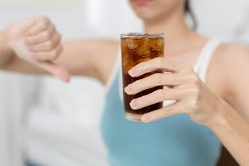women refusing soda with thumbs down gesture, symbolizing healthy lifestyle, sugar reduction, diet...