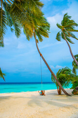 Tranquil closeup calm sea water waves with palm trees. Woman tourist swinging, Tropical island beach landscape exotic shore coast. Summer vacation, holiday amazing nature. Relax paradise, Maldives.