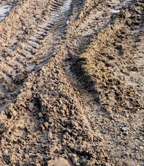 Wheel tracks in the mud. Ruts and puddles. Close-up.