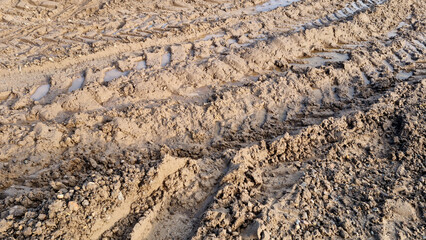 Wheel tracks in the mud. Ruts and puddles. Close-up.