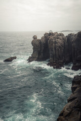 Steely sea under a cloudy sky over the granite cliffs