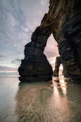 The sunrise behind the arches of As Catedrais beach