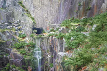 Beautiful waterfall flowing from quarry face at Dinorwic Quarry North Wales landscape