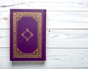 A regal purple book adorned with gold filigree on a white wooden surface
