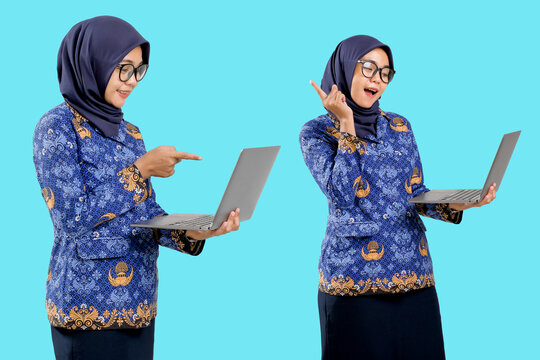 PNS indonesia, ASN indonesia, Guru Indonesia, in civil servant blue batik Korpri uniform pointing at laptop screen, concept of digital education and modern government worker.