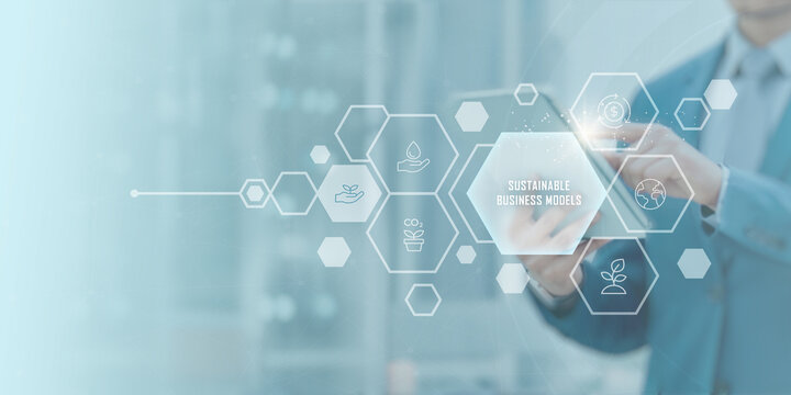 Sustainable Business Models concept — business professional using digital tablet with futuristic eco-friendly interface symbolizing corporate responsibility, green innovation