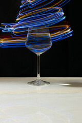 Wine glass with water and neon light on marble table and black background