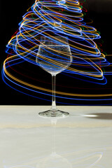 Wine glass with water and neon light on marble table and black background