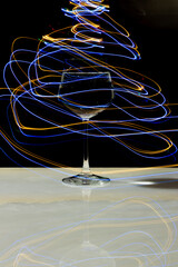 Wine glass with water and neon light on marble table and black background