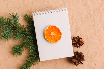 Blank open notebook mock up, to do list, wishlist for Santa, New year and Christmas goals. Christmas eve branch, dried orange, gift. Flat lay, top view, place for text