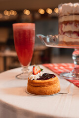 Pastry with a strawberry, with strawberry juice served at a restaurant table.
