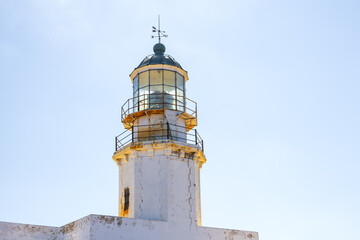 close up view of old white lighthouse on light clear sky background with copy space. Armenistis lighthouse, Mykonos, Greece