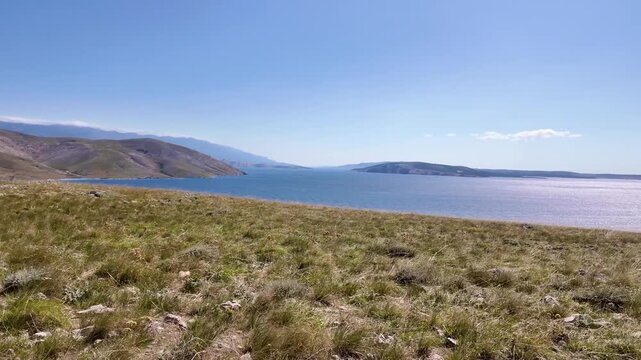 Scenic panoramic view of serene coastal landscape with blue sky and rolling hills