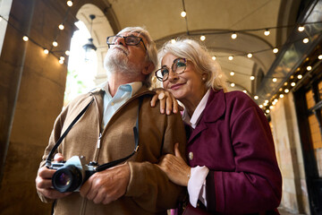 Senior couple traveling exploring city with camera