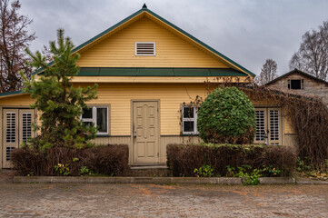 A rustic vintage house with a paved area in front of it.