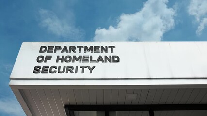 Department of Homeland Security word sign displayed on building facade with clear blue sky, highlighting a government institution focused on national security and public safety.