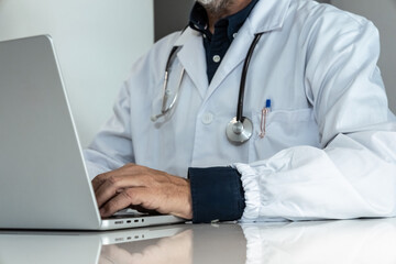 Focused doctor working on a laptop in a modern clinic, leveraging technology for efficient patient management