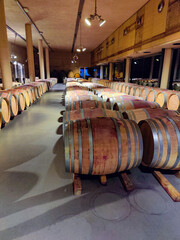 Wine barrels aging in traditional cellar at winery