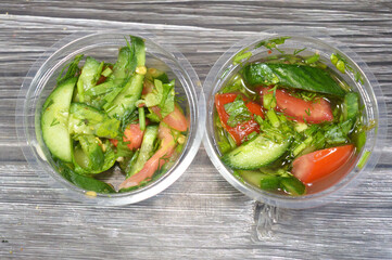 two bowls of Arabic green salad with slices of cucumber, tomatoes and green arugula rocket mixed together, pieces of fresh vegetables mixed together, healthy food and dietary concept, Fresh salad