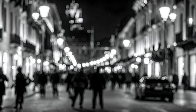 Fototapeta Black and white street scene at night with soft focus, lights and silhouetted people