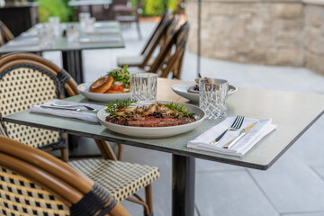 Outdoor dining experience featuring gourmet dishes at a stylish restaurant in a sunny atmosphere