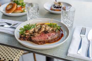 Savoring a delicious plated meal featuring tender beef with mushrooms and herbs at a modern restaurant