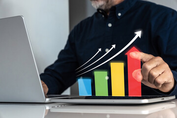 Businessman analyzing financial growth and performance on a futuristic virtual bar chart