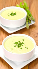Light Green Pureed Soup with Asparagus on Wooden Table
