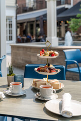 Delightful afternoon tea served in a charming outdoor setting with a fountain backdrop