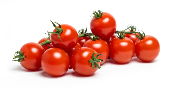 Fresh ripe cherry tomatoes piled together on a white background