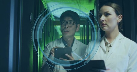 Two IT technicians projecting and analyzing 3D interface in hall, with server racks and tablets