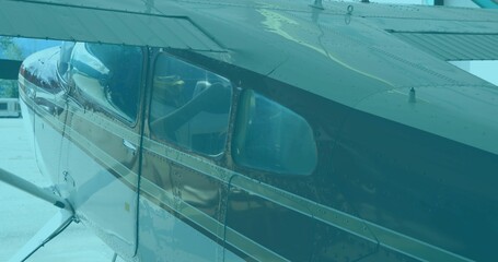 Showing small aircraft fuselage on airport ramp, with cabin windows and wing support struts