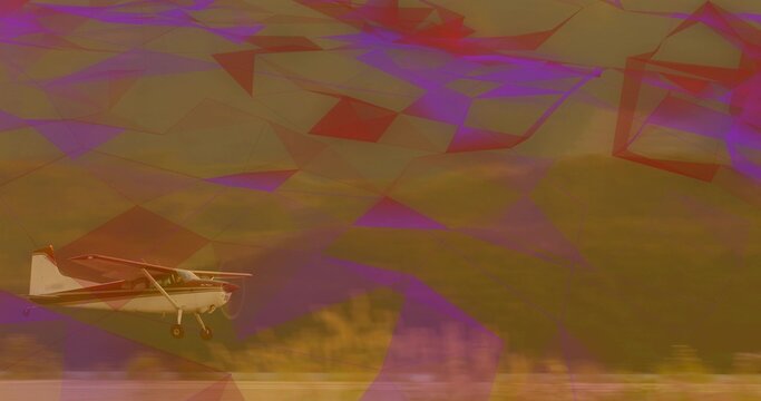 Fototapeta Flying small single-engine propeller airplane skimming grassy field, with landing gear and hillside