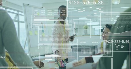 Presenting mid adult man leading discussion at whiteboard by conference table, with data overlays
