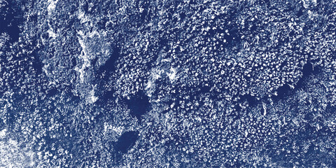 Close-up textured background of dark blue and white granular particles with irregular dark shadows suggesting a rough, gritty surface or abstract material