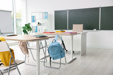 Green chalkboard and stylish furniture in classroom. Mockup for design