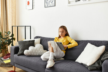 Girl enjoying a quiet afternoon at home with her tablet on the couch